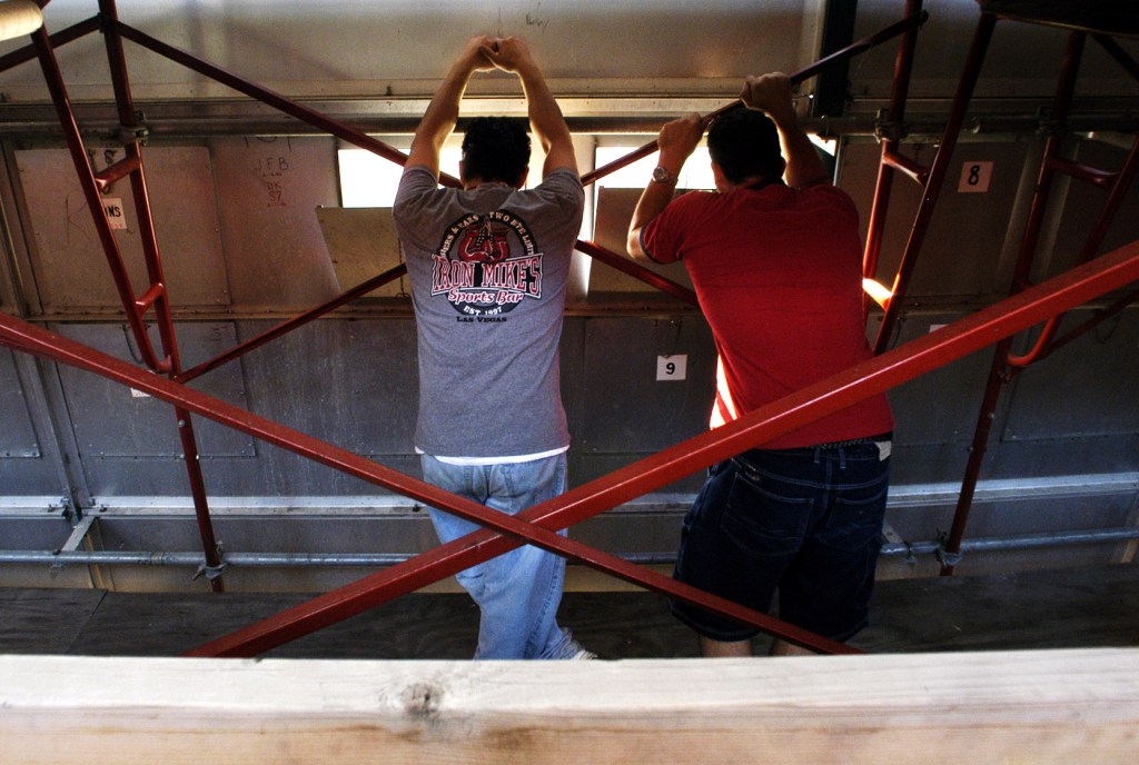 Manual Scoreboard- Manual scoreboard operators Troy Siade, left, and Danny Buffa take in the Cardinals-Giants game from their favorite spot behind the manual scoreboard at Busch Stadium Wednesday night.